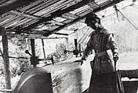 Photo of Dorothea Mitchell operating large, circular lumber saw