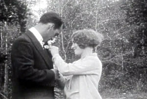 Photo of Dolly Dearborn pinning the flower on Jack Madison, in The Fatal Flower